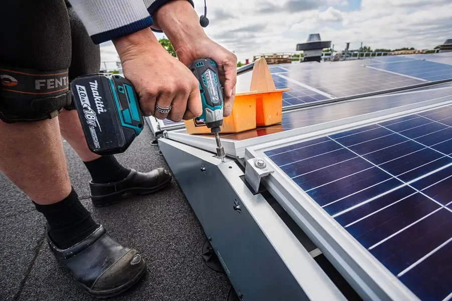 Monteur bevestigt een zonnepaneel met een accuschroevendraaier